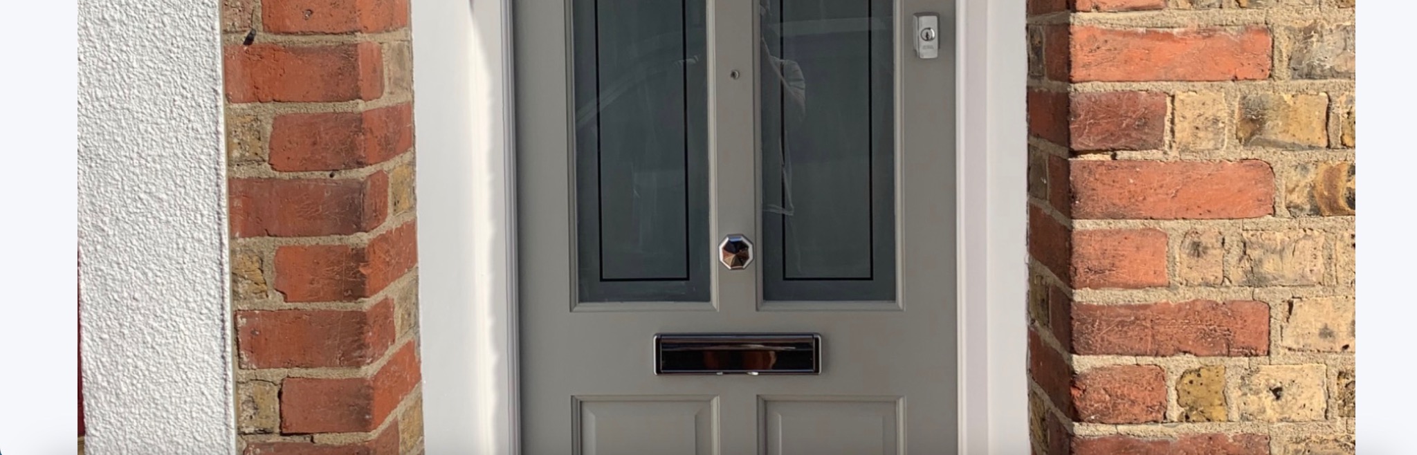 Grey front door repair with glazed panels completed by Hopkins Security